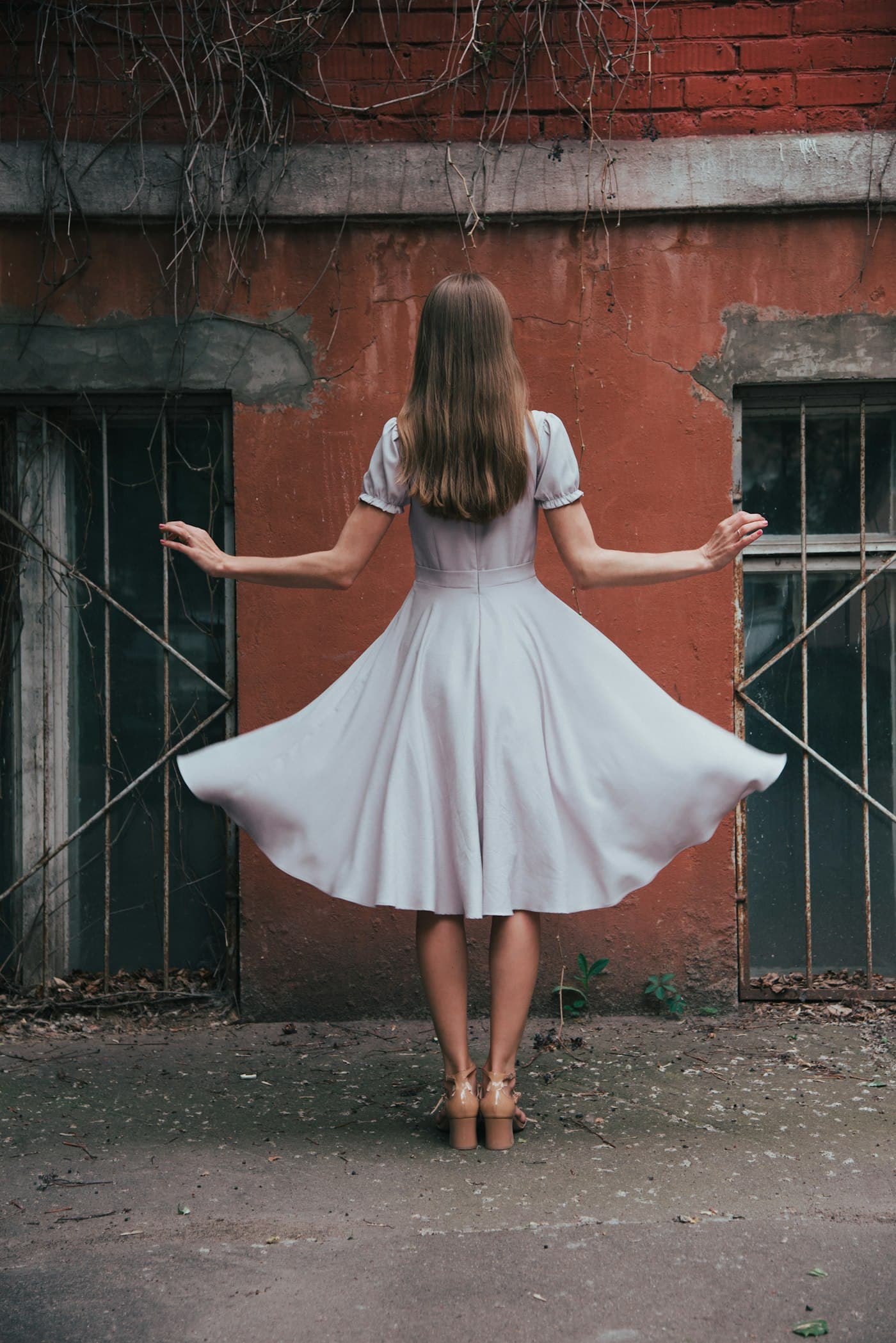 Girl twirling in a white vintage dress